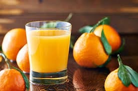 Glass of fresh orange juice with tangerines